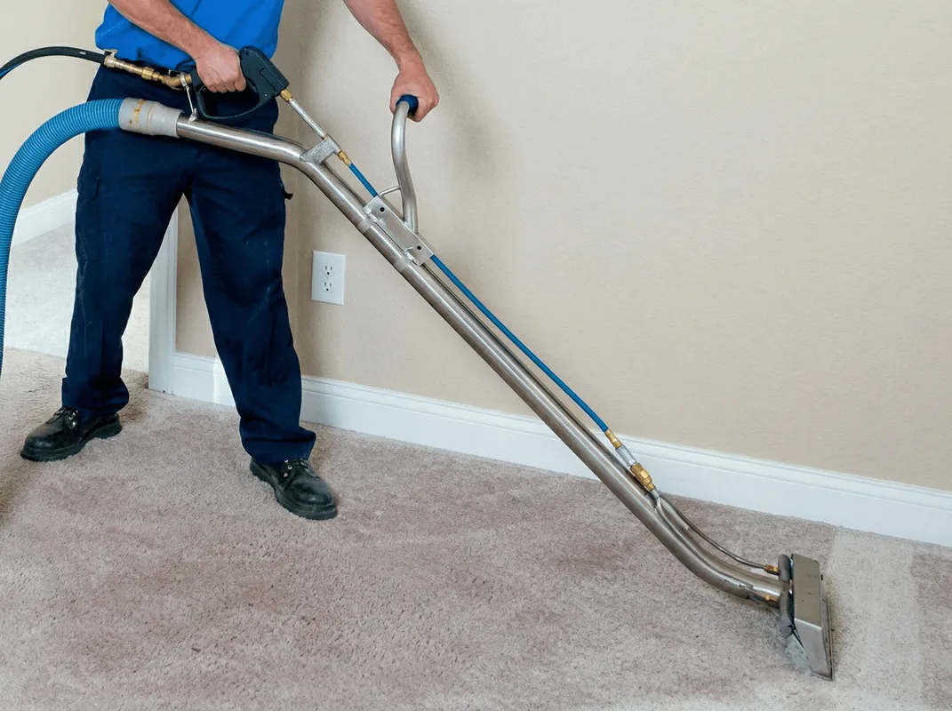 Professional operating a liquid removal machine on a carpeted floor in Dover, DE